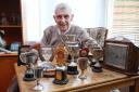 Bob McGaughey with his own personal collection of trophies won all over the country for open air swimming