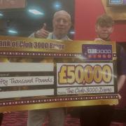 Gerry Chisholm, manager of Club 3000 in Greenock, shows off the cheque with staff