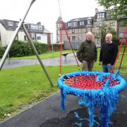 Councillors Michael McCormick and Colin Jackson look at the vandalised swing in Bawhirley playpark