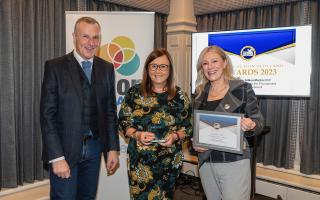 Jacqueline Coyle (centre) receives her award from Energy Action Scotland chief executive, Frazer Scott and Gillian Martin MSP, Minister for Energy.